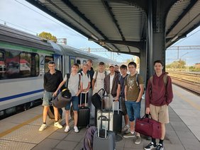 Gruppe Jugendlicher am Bahnhof mit Gepäck