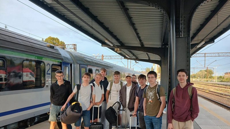 Gruppe Jugendlicher am Bahnhof mit Gepäck
