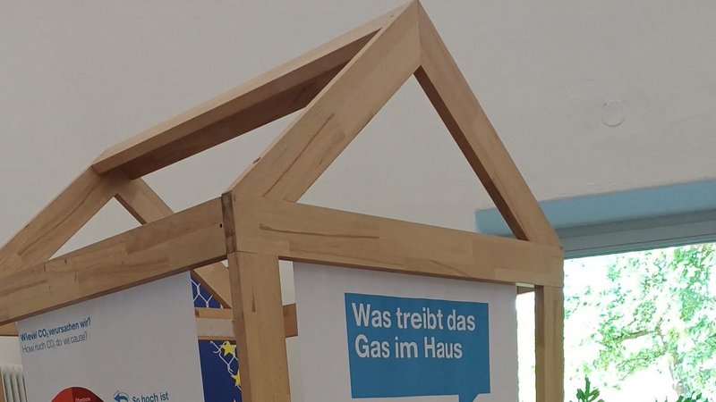 Interaktive Ausstellungsstation zum Treibhauseffekt in Form eines Holzhauses